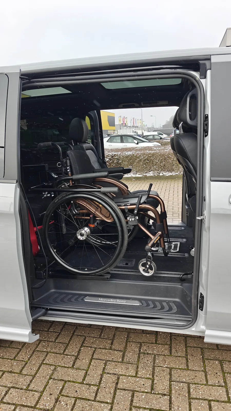 Rolstoel op de Rolpollo-lift achter de schuifdeur, op de tweede zitrij van de personenbus