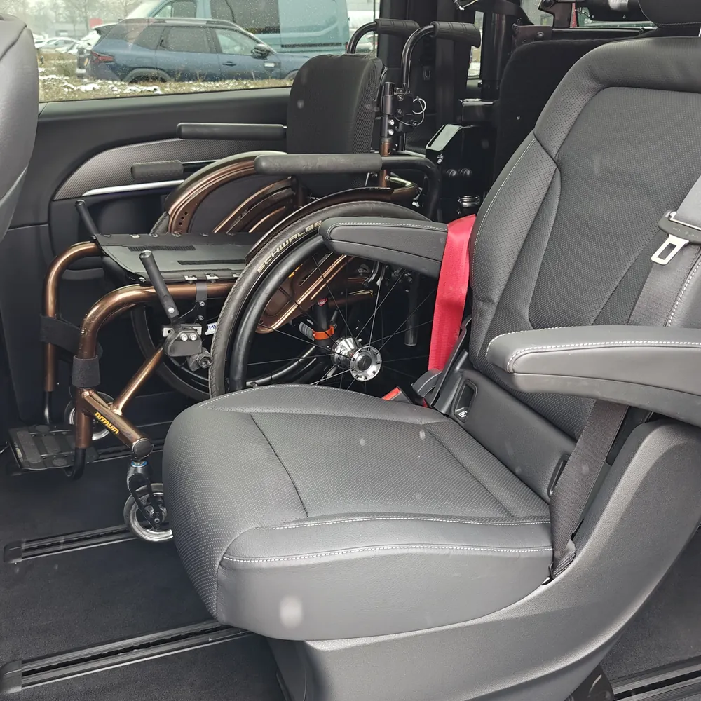Rolstoel vastgezet op de tweede zitrij naast een originele stoel in de personenbus met Rolpollo