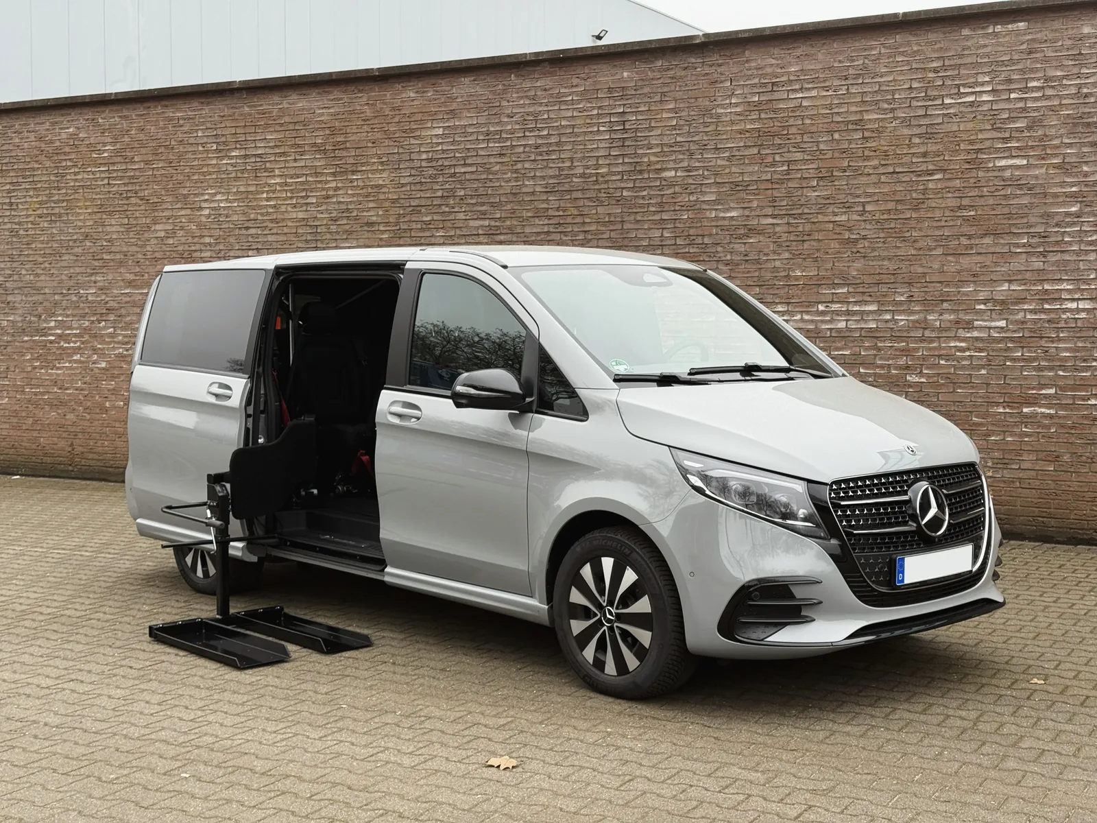 Rolpollo rolstoellift naast de schuifdeur van een Mercedes-Benz personenbus